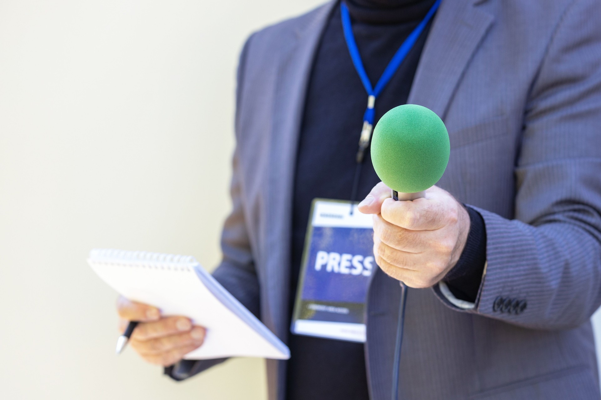 Correspondent holding microphone making media interview