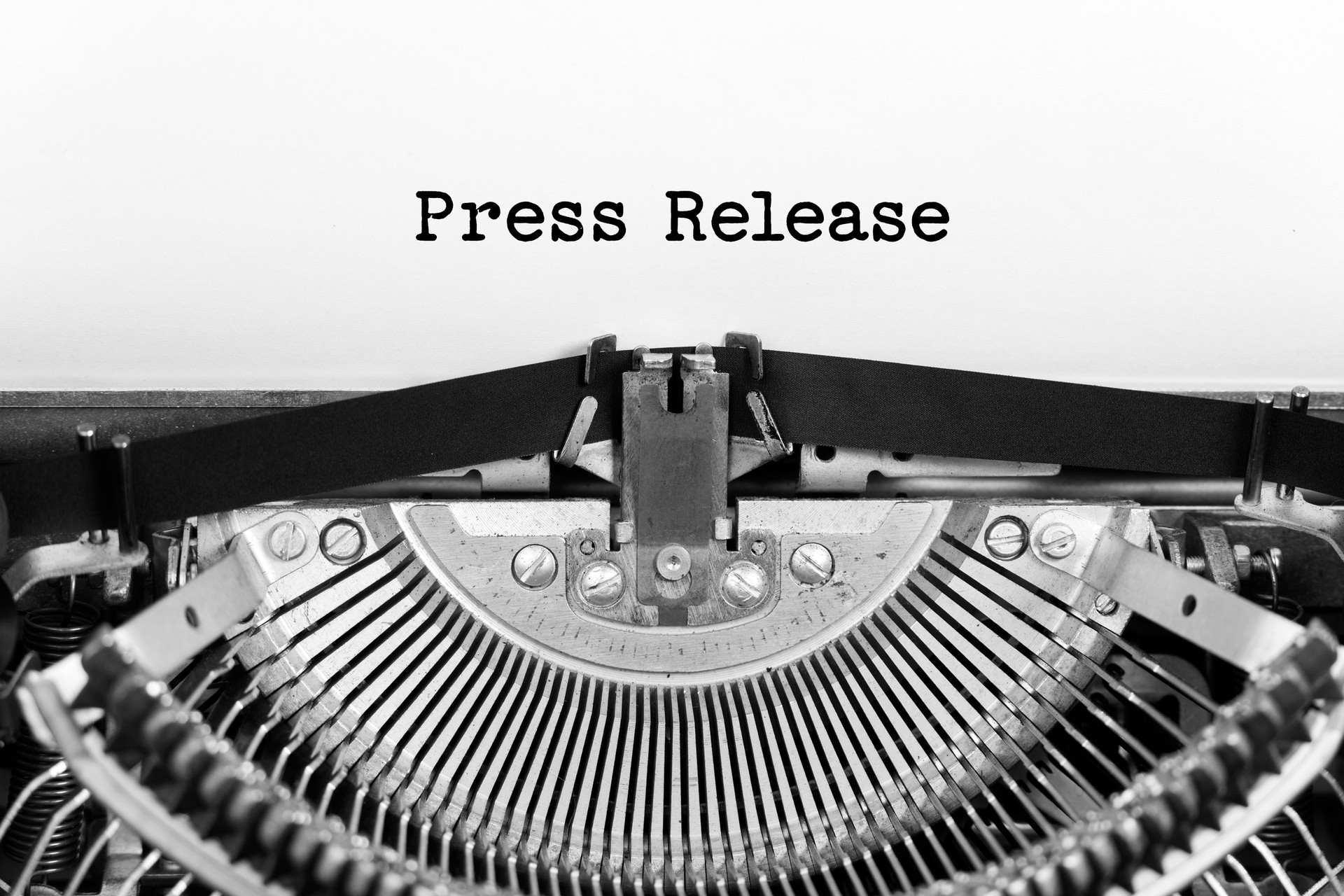 Press Release phrase closeup being typing and centered on a sheet of paper on old vintage typewriter mechanical